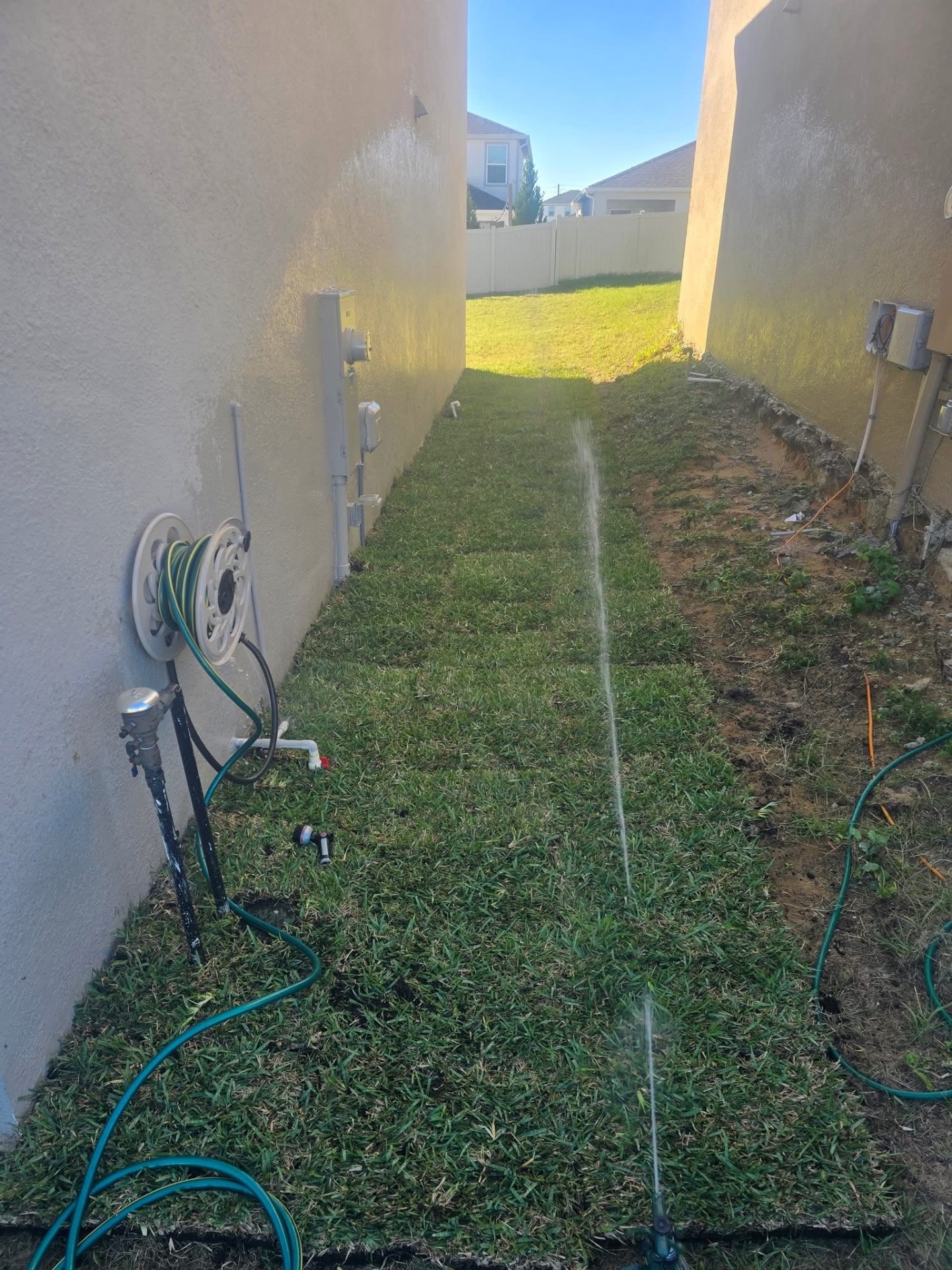 After — fresh sod installed with sprinkler system running