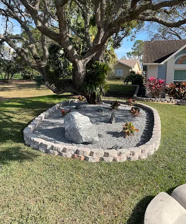 Stone garden bed with decorative rocks and plants